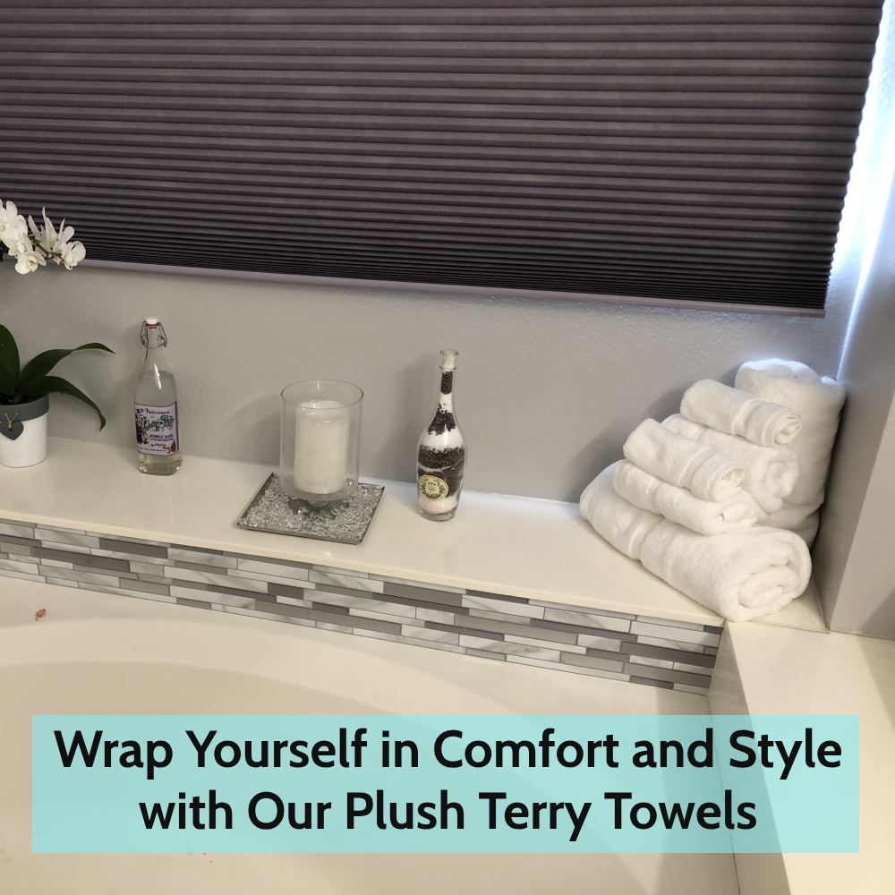 Rolled and folded white bath towels stacked beside a bath